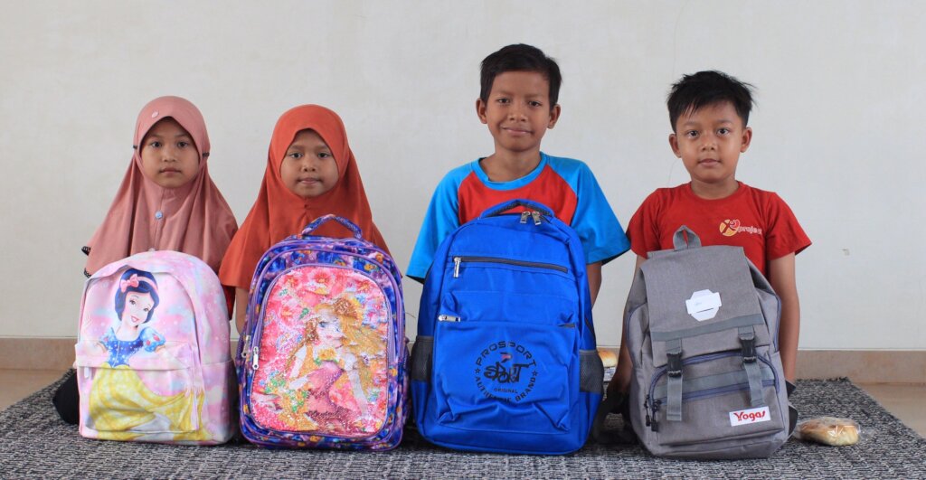 Indonesian school children with their school bags waiting to go to school in Jakarta