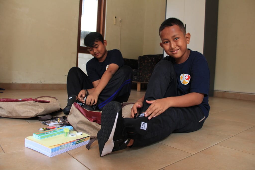 One of the children from the XSProject Foundation smiles happily while trying on new shoes for school.