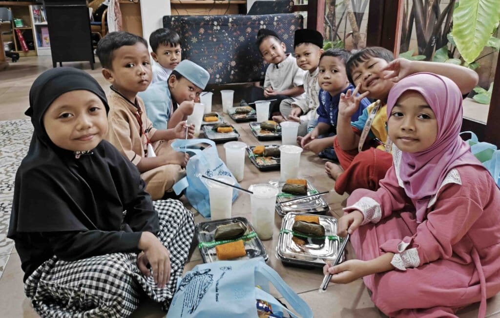 Children sitting together sharing a meal indoors