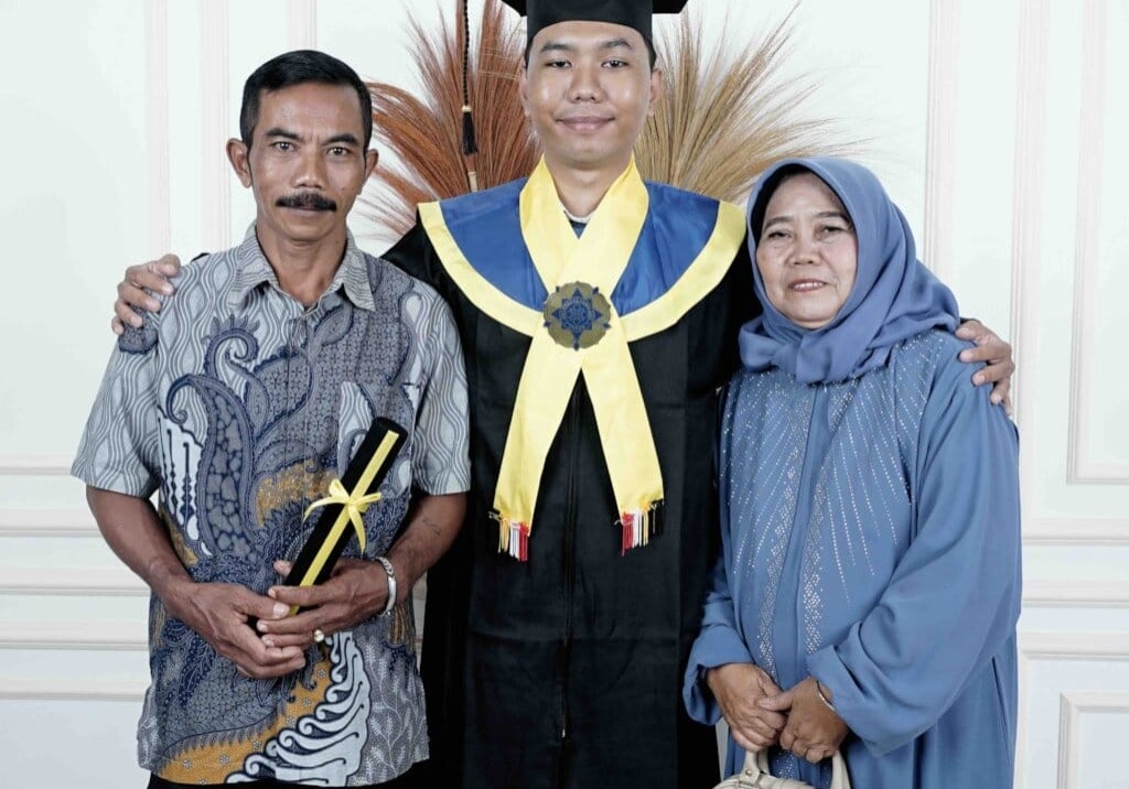 Graduate with parents in traditional attire